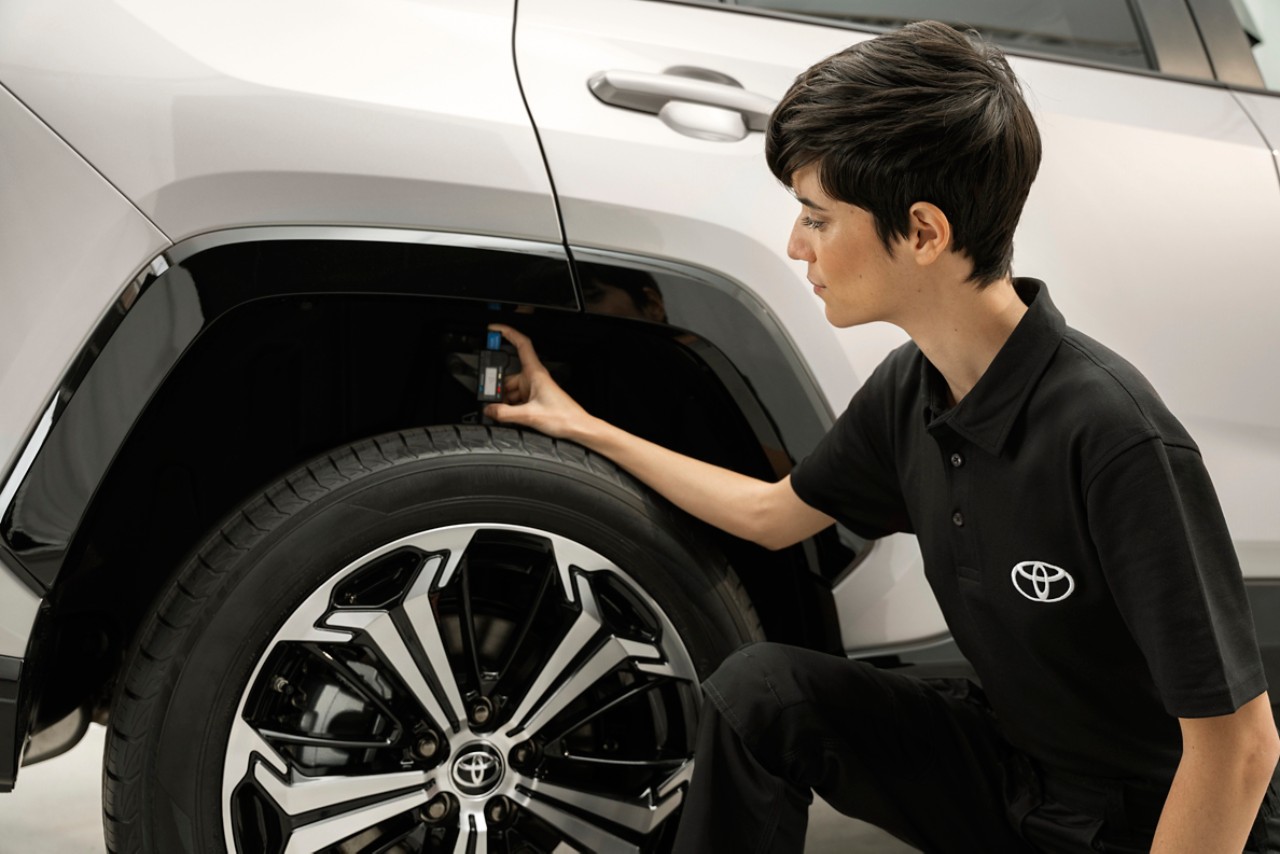 Toyota maintenance team member checking tyre pressure on a Toyota vehicle