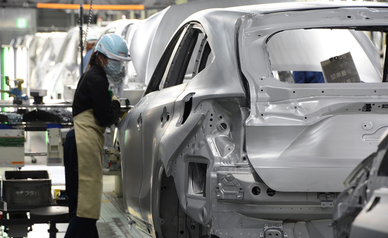 Person in a factory, manuactoring a vehicle