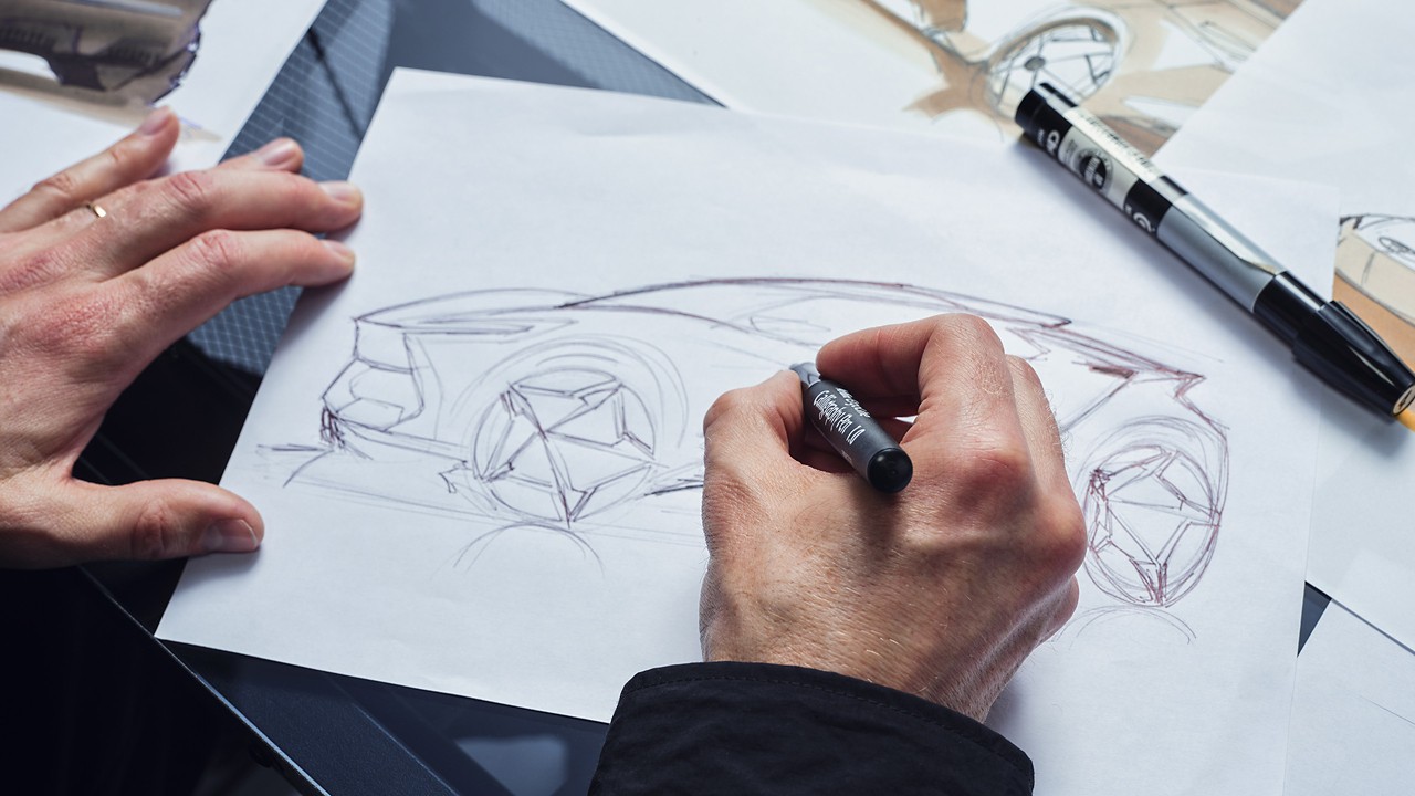 Person sketching an image of a car