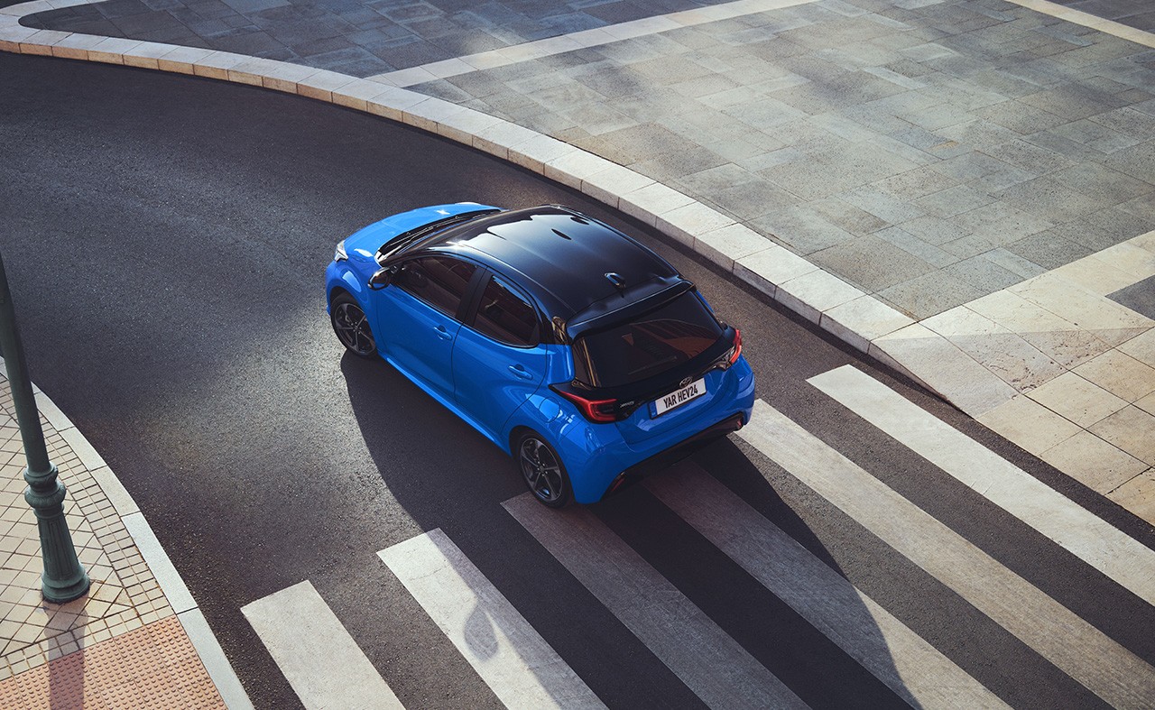 Blue Toyota Yaris driving on a road