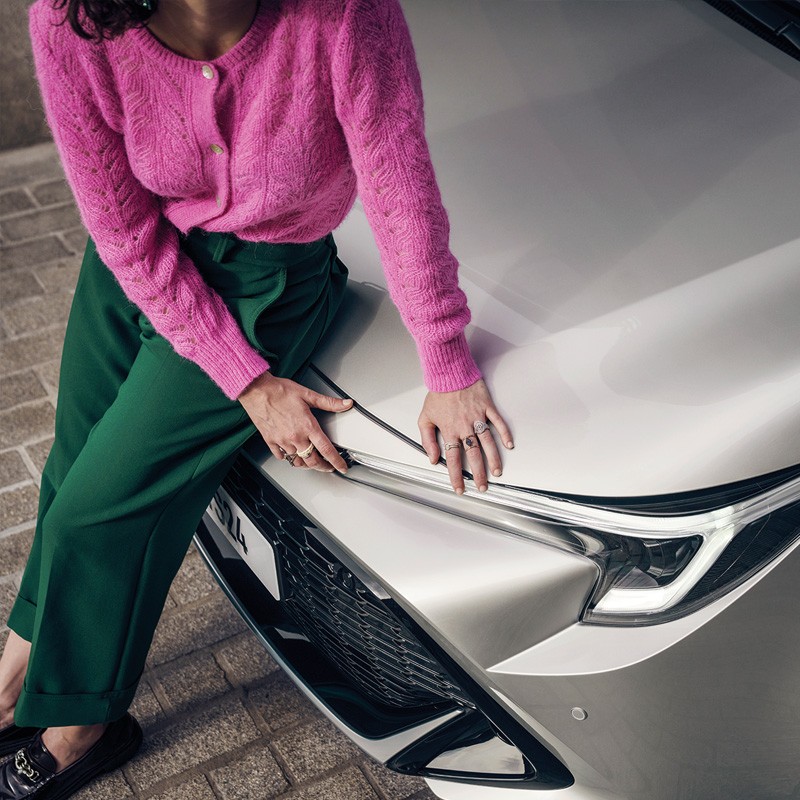 Woman leaning on a Toyota 