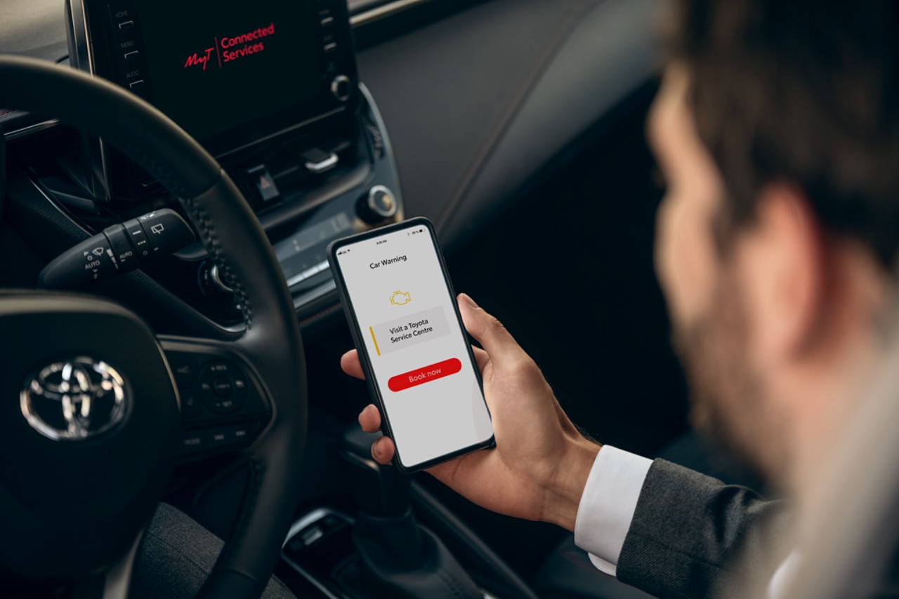 A Toyot driver connecting their phone to their car with the MyToyota app