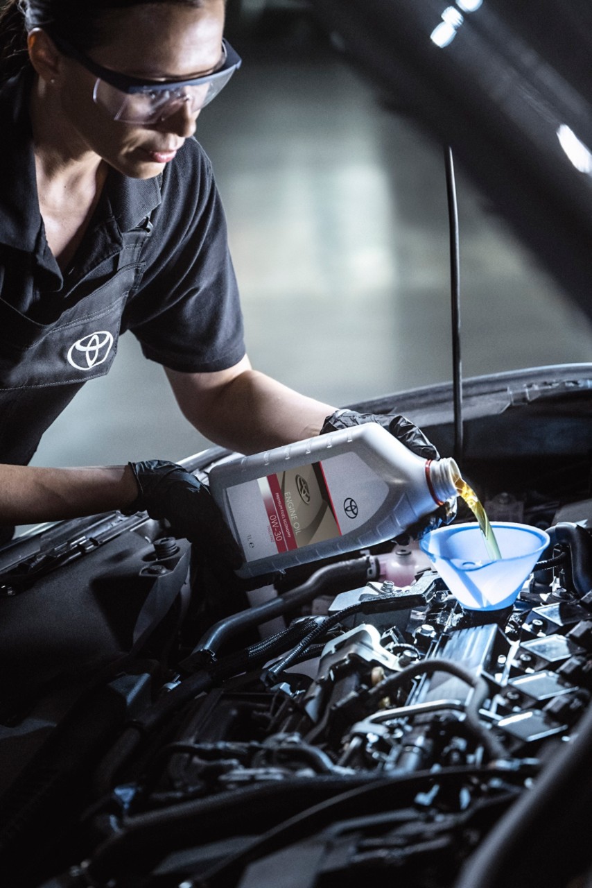 Toyota  team member performing maintenance on a Toyota car